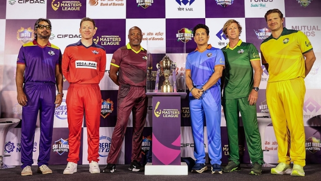 Legendary cricketers Brian Lara, Eoin Morgan, Kumar Sangakkara, Sachin Tendulkar, Jonty Rhodes, and Shane Watson pose in team kits around the trophy at the launch of the International Masters League 2025.