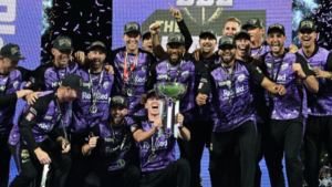 Hobart Hurricanes players celebrate their Big Bash League (BBL) 2025 championship victory, holding the trophy and wearing winners' caps on stage.