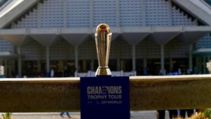 ICC Champions Trophy 2025 trophy on public display during its official tour, with a building in the background and a DP World banner.