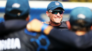 Pierre de Bruyn, coach of Cricket Namibia, leads a team huddle with players during a match.