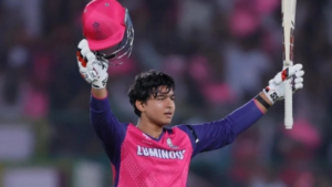 Vaibhav Sooryavanshi celebrates his maiden T20 hundred for Rajasthan Royals, raising his bat and helmet in front of a cheering crowd.