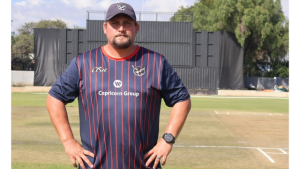 Gerhard Lotter, newly appointed assistant coach of Cricket Namibia, standing on a cricket field in team training kit.