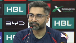 Karachi Kings Director Haider Azhar speaks at a press conference during the Pakistan Super League, with sponsor logos in the background.