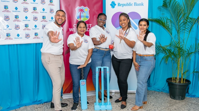 Representatives from Republic Bank and Cricket West Indies pose together at a promotional event, standing beside cricket stumps and branded backdrops.