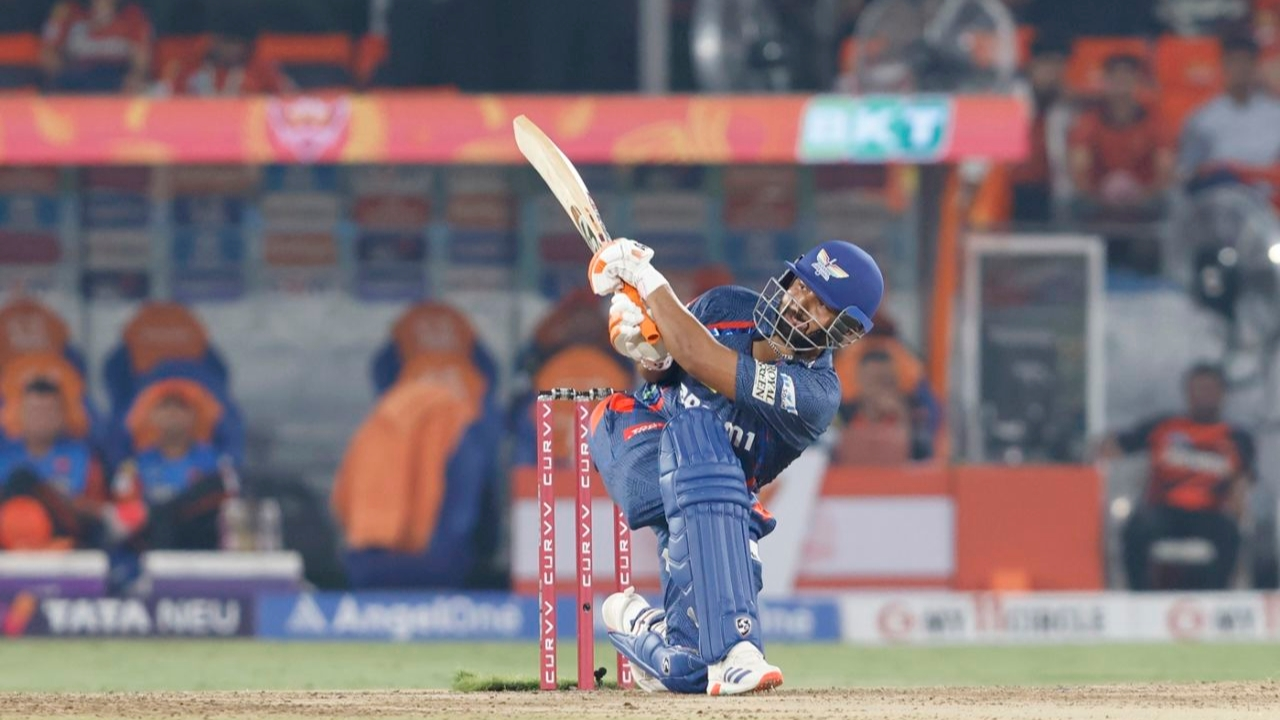 Rishabh Pant plays an aggressive shot during an IPL 2025 match, wearing the Delhi Capitals jersey.