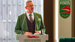 Sean Jarvis, CEO of Leicestershire County Cricket Club, speaking at a podium with club branding and Leicestershire Foxes logo in background