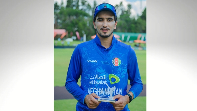 Afghanistan cricketer Sediqullah Atal holding a player award while posing on the field after a match