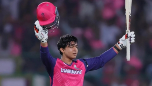 Vaibhav Sooryavanshi celebrates a cricket milestone, raising his bat and helmet while wearing the Rajasthan Royals jersey.