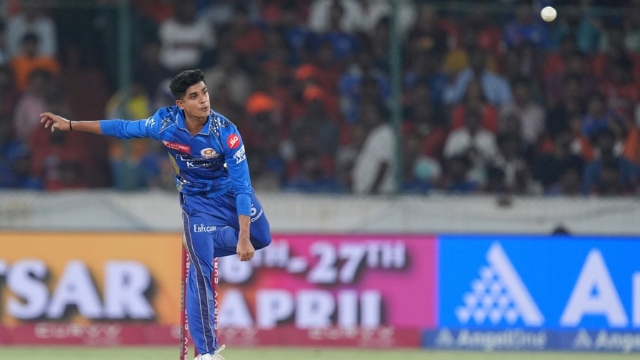 Mumbai Indians bowler Vignesh Puthur delivering a ball during an IPL match, with the crowd in the background.