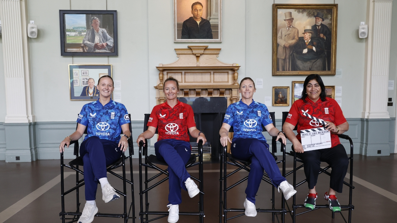 Three England women cricketers alongside Gurinder Chadha, the renowned filmmaker, all dressed in England's cricket jerseys, posing for a photo.