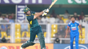 Glenn Maxwell of Australia plays an aggressive shot during a cricket match against India, captured mid-swing in action.