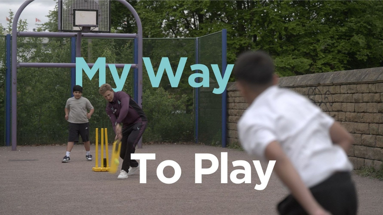 Joe Root playing street cricket with children on an urban playground, promoting youth engagement in sports.