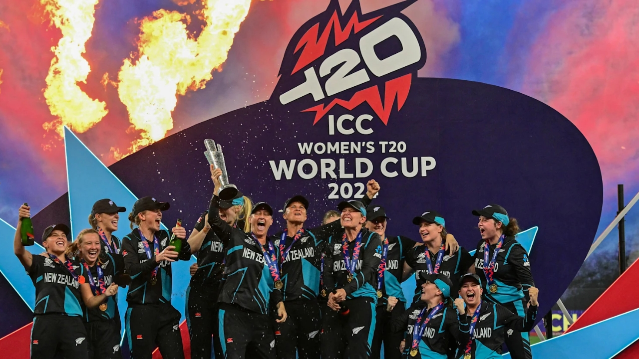 New Zealand Women's Cricket Team celebrates their victory with the trophy after winning the ICC Women’s T20 World Cup 2024, with fireworks in the background.