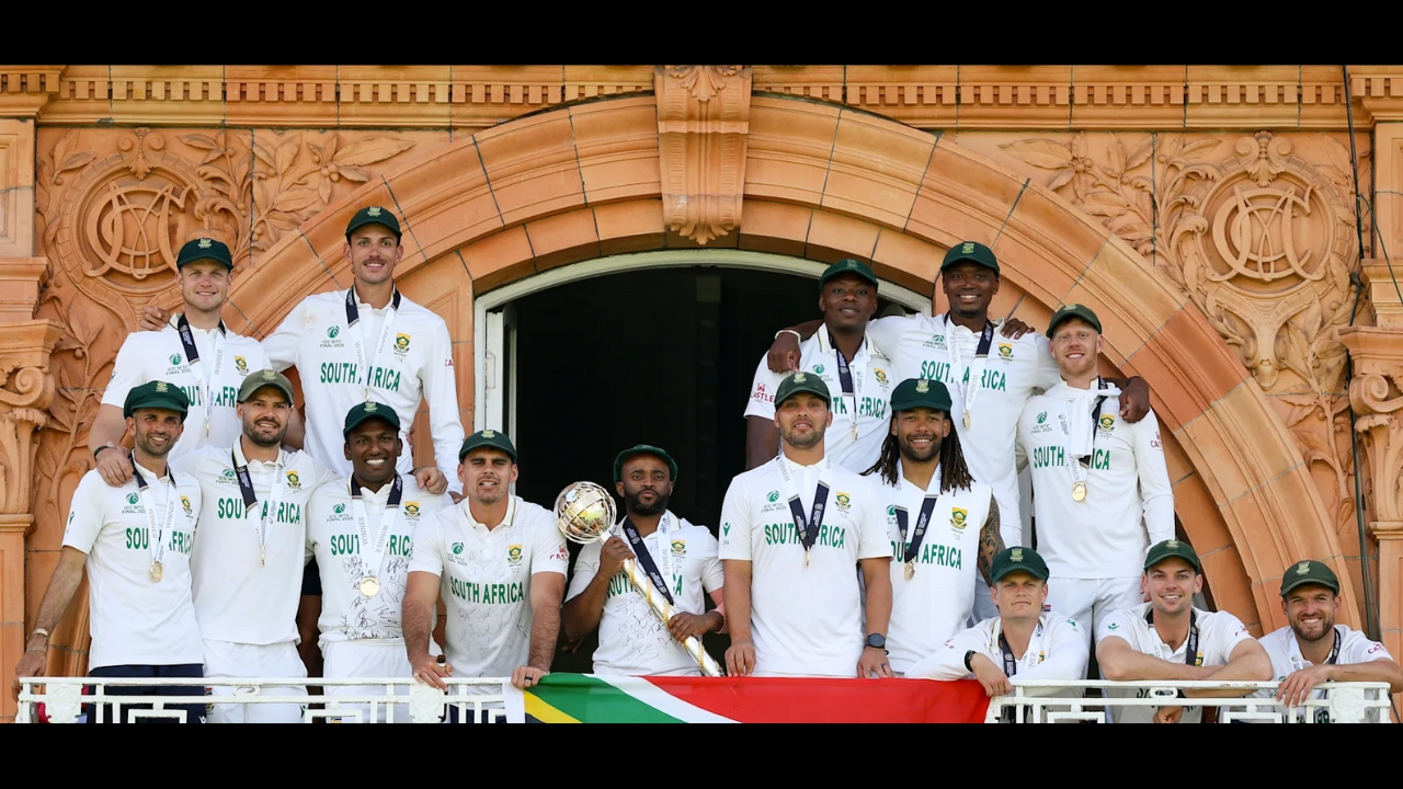 South Africa men’s cricket team posing with the ICC World Test Championship 2025 mace on the balcony at Lord’s Cricket Ground, with the South African flag displayed.