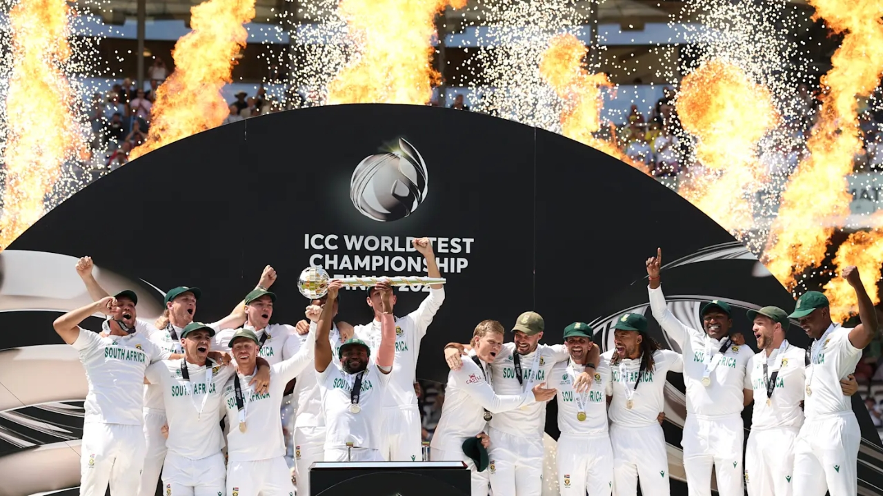 South Africa men’s cricket team celebrating with the ICC World Test Championship 2025 trophy on stage, with flames and fireworks in the background.