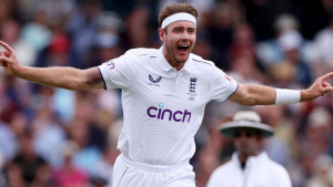 Stuart Broad of England celebrates after taking a wicket during a Test cricket match, wearing the England whites with arms outstretched.