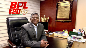 Amin Ul Islam seated at his office desk with the Bangladesh Premier League (BPL) 2024 logo in the background.