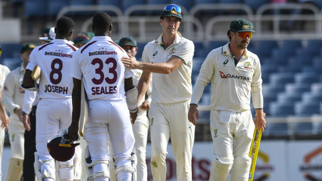 Pat Cummins and Travis Head of Australia greet West Indies players Jayden Seales and Alzari Joseph after a Test match.