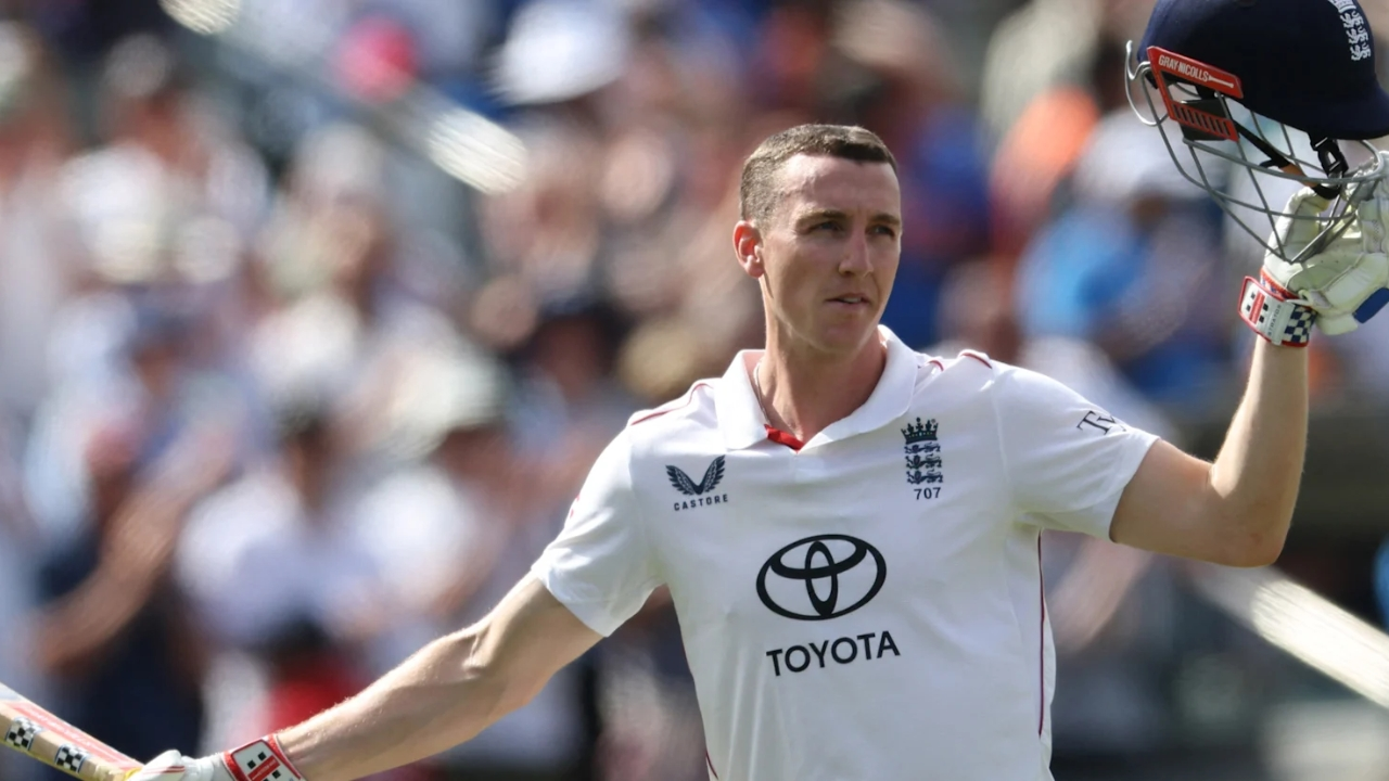 Harry Brook celebrates in England Test cricket jersey, raising his helmet and bat during a match.