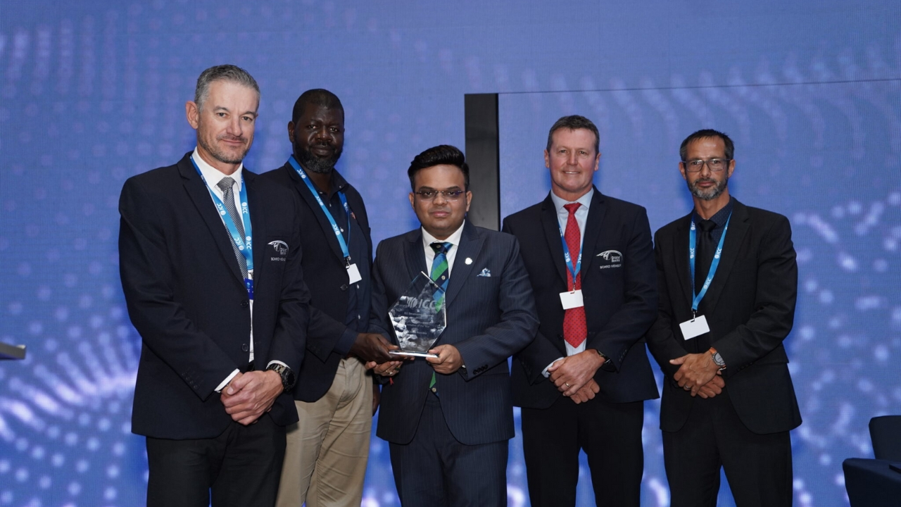 Jay Shah receiving an ICC award while posing with Polly Negongo, Johan Muller, and two other officials in formal attire against a blue background.