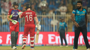 England cricketers Jos Buttler and Eoin Morgan celebrate during a T20 match against Sri Lanka, with a Sri Lankan bowler walking past in the background.