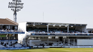 View of the Frank Woolley Stand at Kent County Cricket Ground on a sunny match day with scattered spectators.