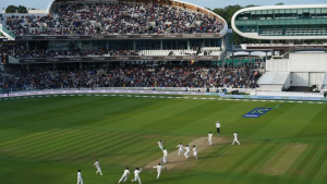 View of Lord's Cricket Ground during a test match with players celebrating a wicket and a packed crowd in the stands.