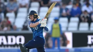 England cricketer Nat Sciver-Brunt in batting action during a match, wearing blue kit and swinging the bat with focus.