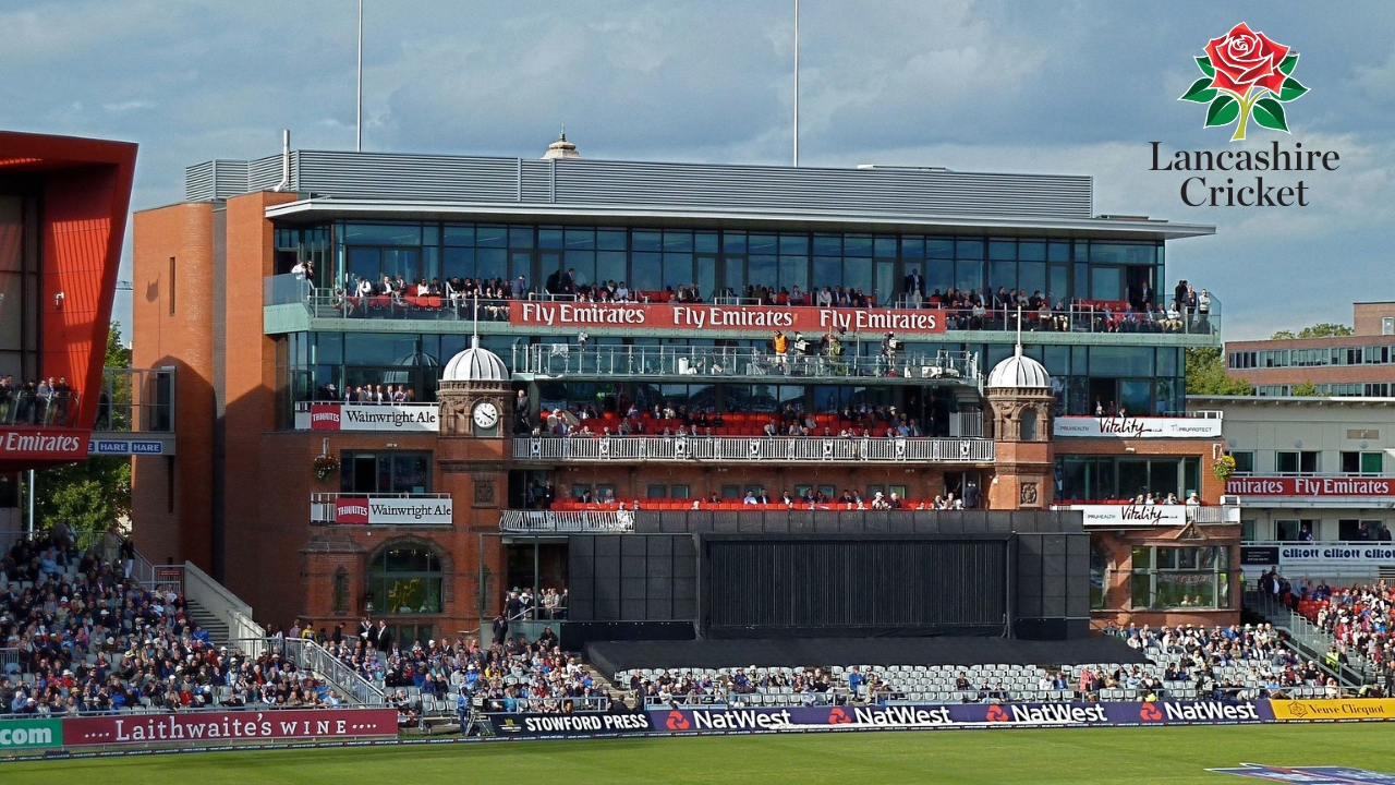 Old Trafford cricket stadium packed with spectators, featuring the Lancashire Cricket Club logo in the top right corner.
