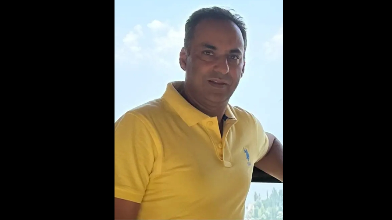 Rashid Shah, board member of Marketing and Communications at KNCB, posing outdoors in a yellow polo shirt.