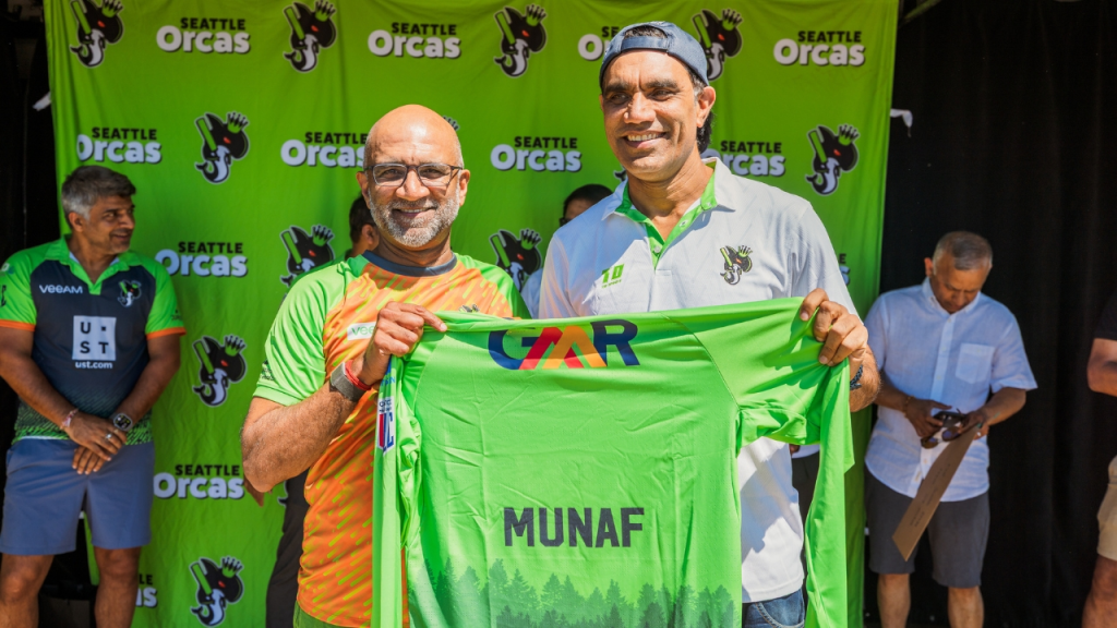 Sanjay Parthasarathy presenting a Seattle Orcas jersey with GMR logo to Munaf Patel during a team event.