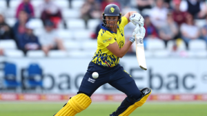 Suzie Bates batting during a T20 cricket match in a yellow and blue uniform, focused on playing a shot.