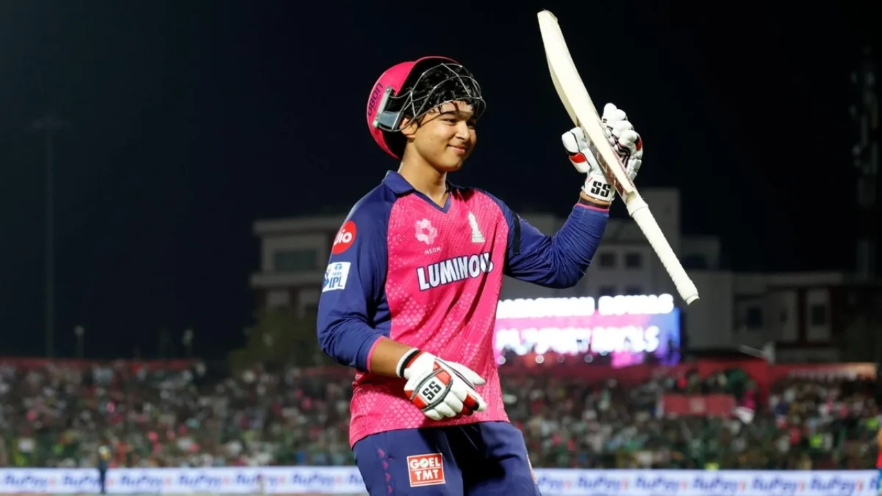 Vaibhav Sooryavanshi celebrates with bat in hand after a match for Rajasthan Royals during an IPL game at night.