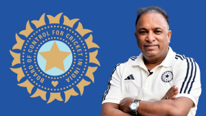 Devajit Lon Saikia posing in front of the BCCI (Board of Control for Cricket in India) logo, wearing a BCCI-branded polo shirt against a blue background.