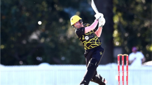 Cricket player in black and yellow jersey playing a powerful shot during a KFC T20 Max match