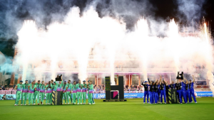 The Hundred 2024 men's and women's teams celebrating with trophies on the field under fireworks after winning the tournament.