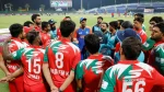 Oman cricket team in a huddle with Indian captain Suryakumar Yadav during Asia Cup 2025 at a stadium under lights