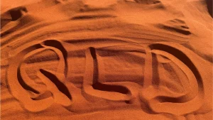 QLD written in red desert sand, symbolizing Queensland, Australia