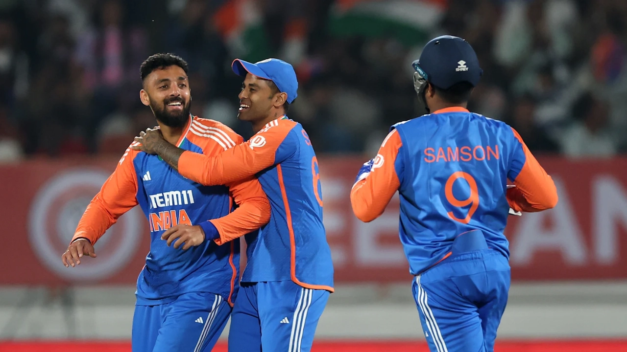 Indian cricket team players celebrate a wicket during a T20 match, with Sanju Samson and teammates in new blue-and-orange jerseys.