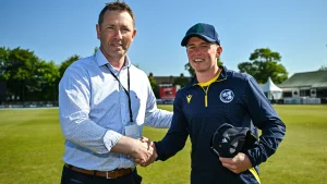 Andrew White shakes hands with Cade Carmichael during a cricket event in Ireland