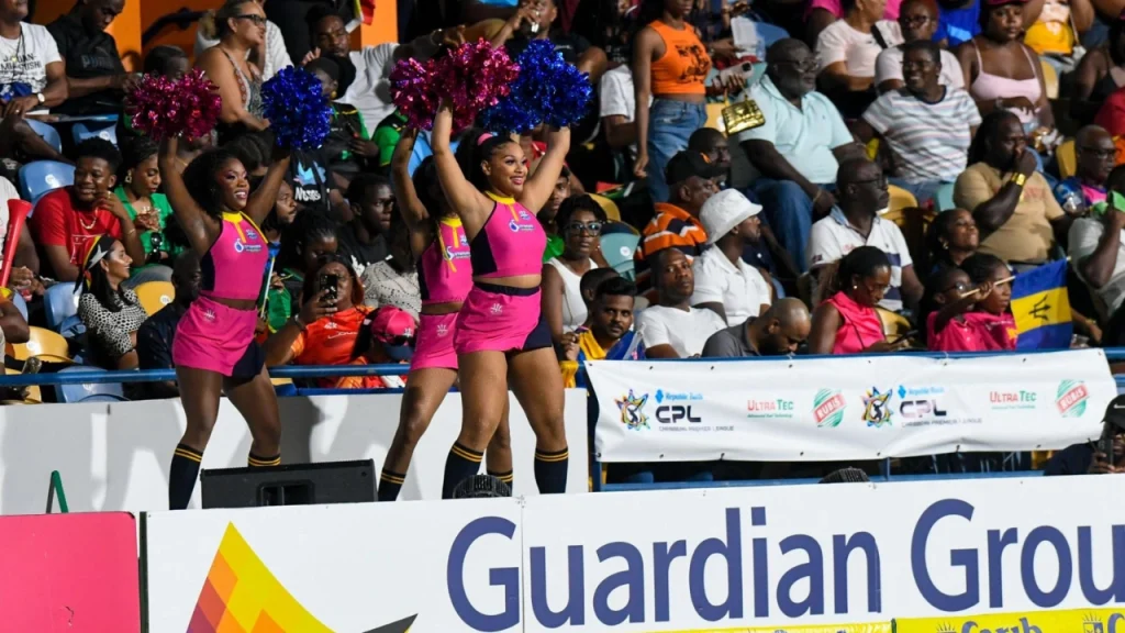 Cheerleaders performing with pom-poms during a Caribbean Premier League (CPL) 2025 match, entertaining a lively crowd in the stadium.