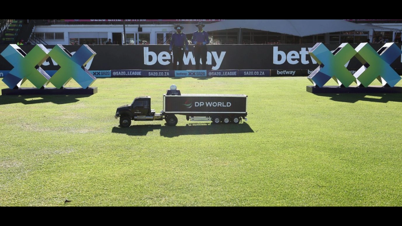 Miniature DP World truck on a cricket field with Betway branding in the background during an SA20 League match.