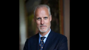 Portrait of Ed Smith, President of Marylebone Cricket Club (MCC), wearing a navy suit and patterned tie.
