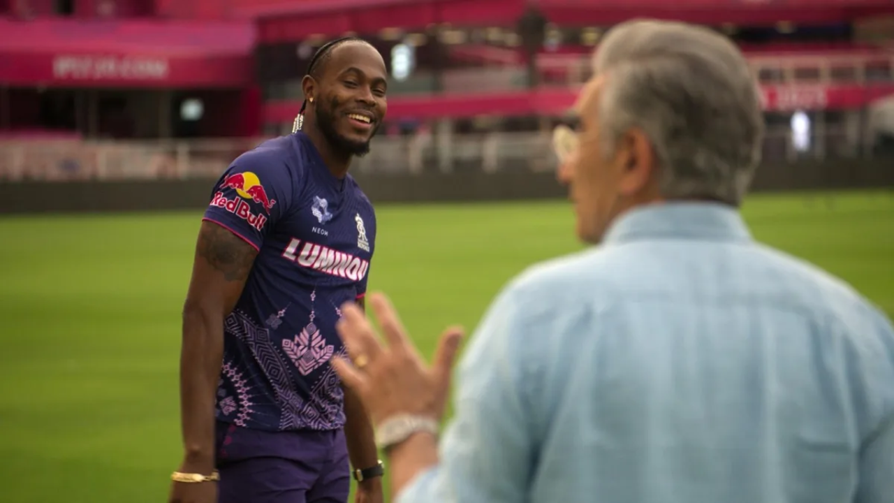 Eugene Levy speaking with Jofra Archer in Rajasthan Royals kit on a cricket field