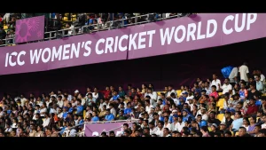 Cricket fans in the stadium stands under a banner for the ICC Women’s Cricket World Cup 2025, showcasing strong crowd support for the tournament.