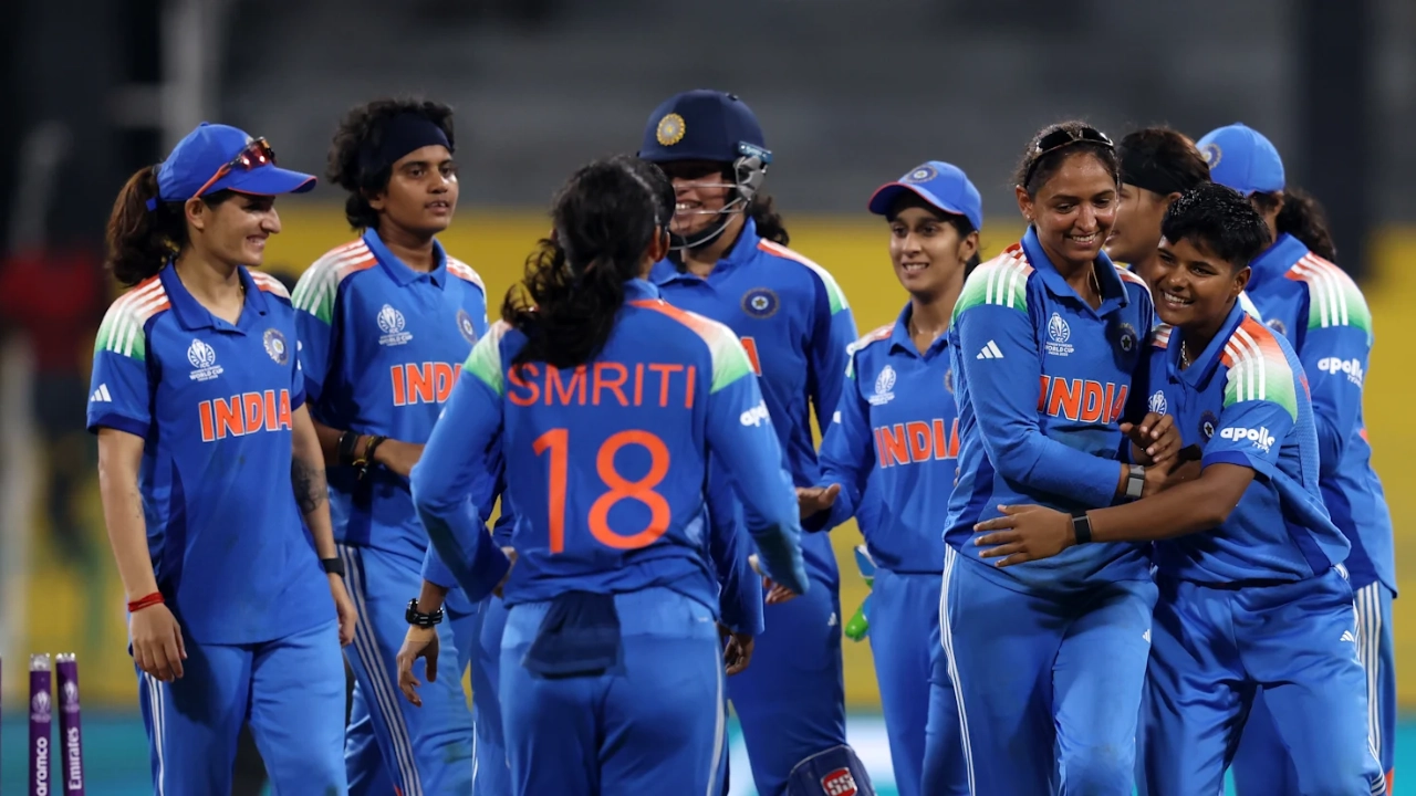 India Women's Cricket Team players celebrating on the field in blue jerseys during a match