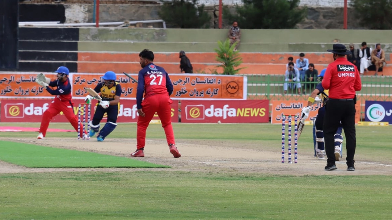 Kabul Premier League cricket match featuring bowler E. Habibi and a Kabul Zalmi batter, with the umpire, wicketkeeper, and advertising boards in view.