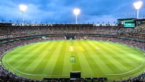 Wide-angle view of a night cricket match at the Melbourne Cricket Ground with a packed crowd and players on the field.