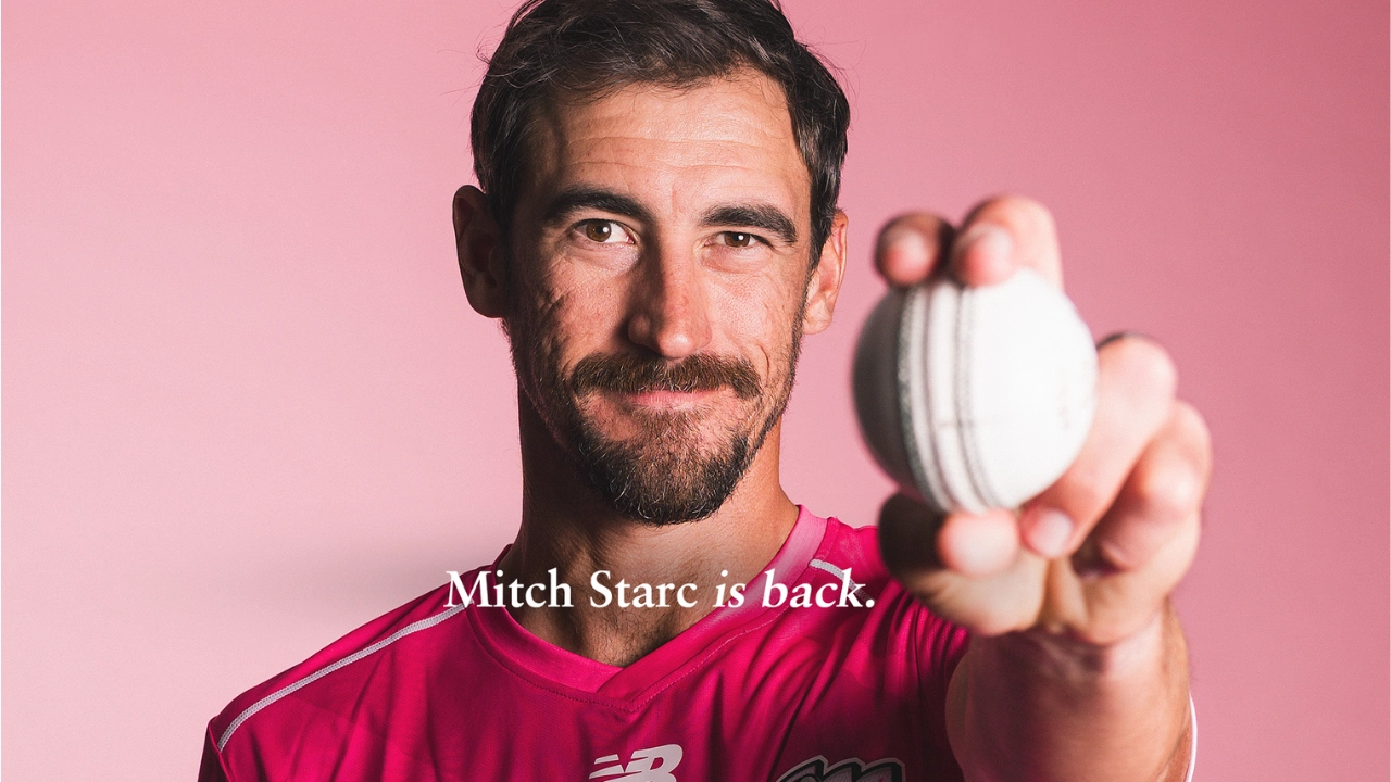 Mitchell Starc holding a cricket ball while wearing the Sydney Sixers jersey, announcing his return to cricket.