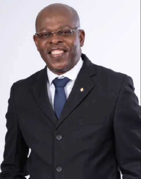 Preston George, General Manager of Marketing at Republic Bank, smiling in a formal suit and tie against a plain background.